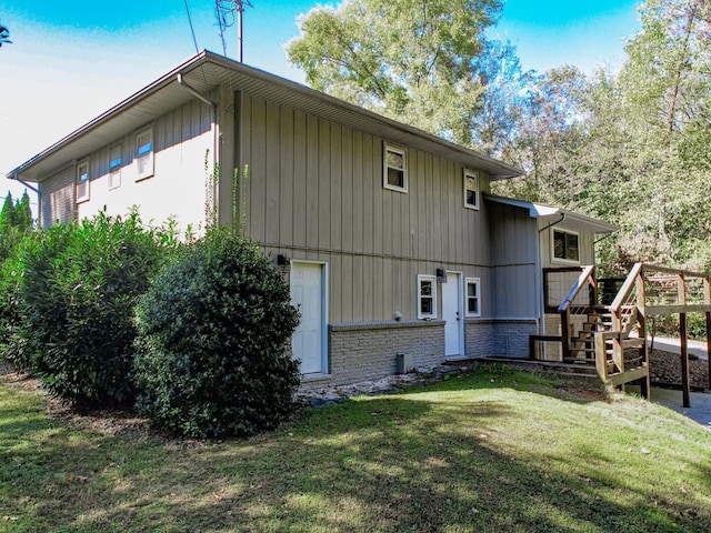 back of property with a lawn and a wooden deck