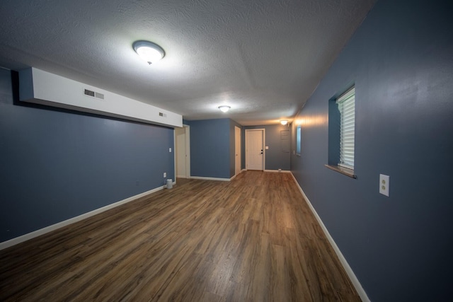 basement with dark hardwood / wood-style flooring and a textured ceiling