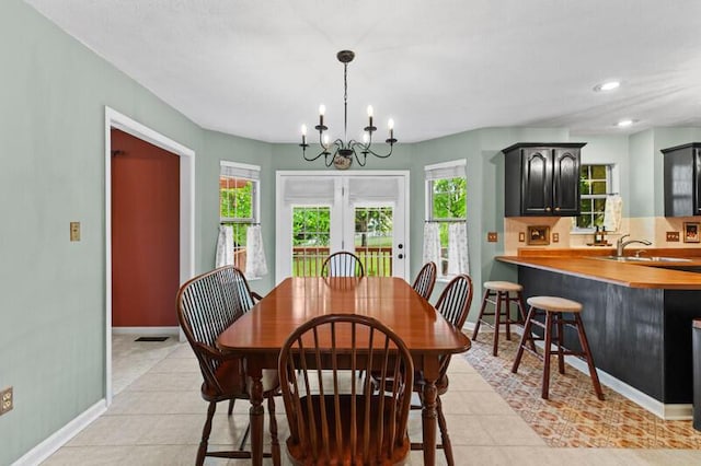dining room featuring french doors, light tile patterned floors, baseboards, a chandelier, and recessed lighting