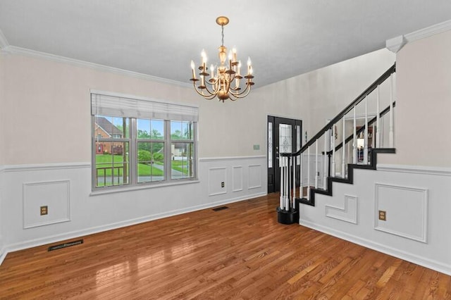 interior space with visible vents, a chandelier, wainscoting, and stairway