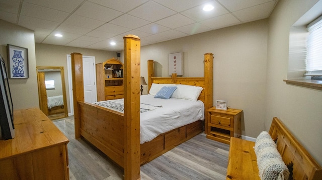 bedroom with a drop ceiling and hardwood / wood-style floors