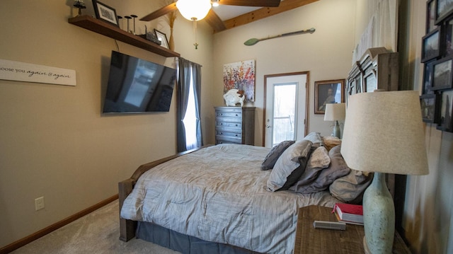 carpeted bedroom featuring beamed ceiling and ceiling fan