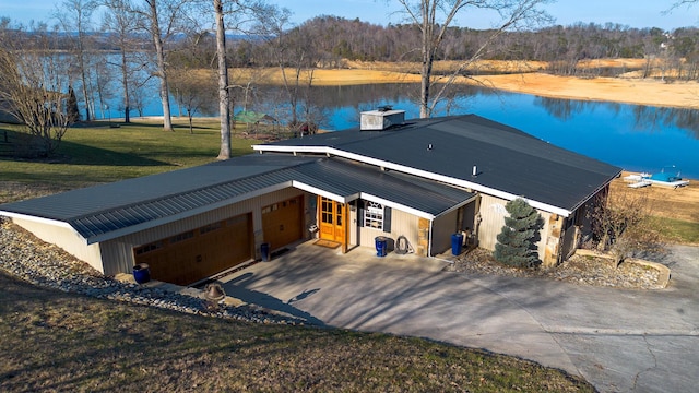 view of front of house featuring a water view, a garage, and a front lawn