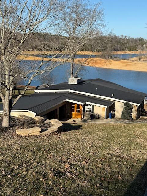 back of property featuring a water view