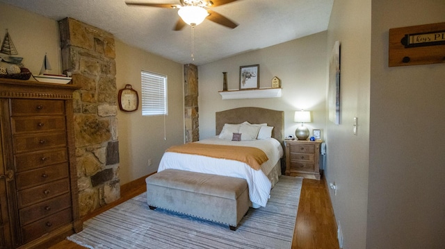 bedroom with wood-type flooring, ceiling fan, and vaulted ceiling