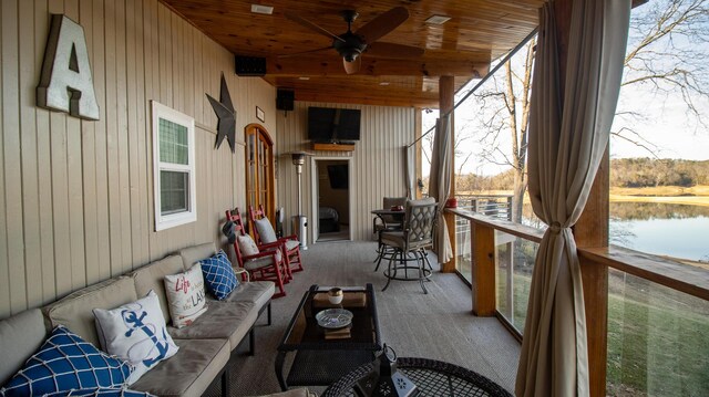 sunroom / solarium featuring beam ceiling, wooden ceiling, and ceiling fan