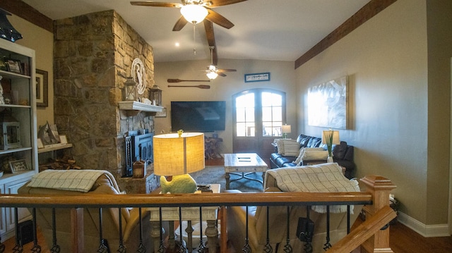 living room with ceiling fan, a fireplace, hardwood / wood-style floors, and vaulted ceiling with beams