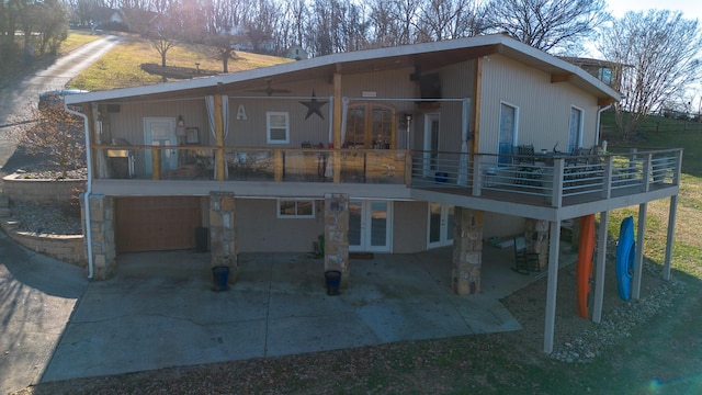 rear view of property featuring a garage, a patio area, and french doors