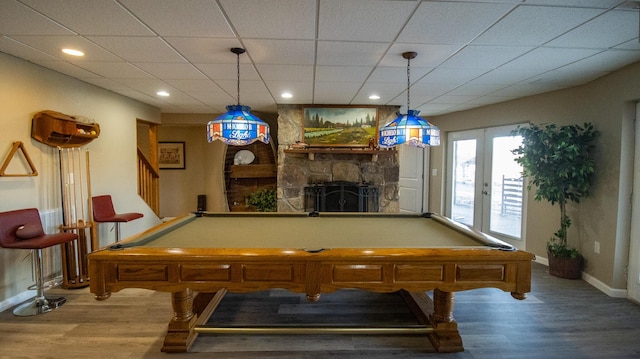 playroom with hardwood / wood-style flooring, a paneled ceiling, a fireplace, and french doors