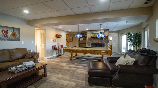 living room featuring a paneled ceiling, hardwood / wood-style floors, a fireplace, and billiards