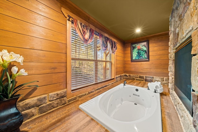 bathroom featuring hardwood / wood-style floors, a washtub, and ornamental molding