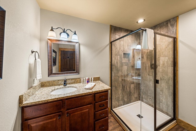 bathroom featuring vanity and a shower with shower door