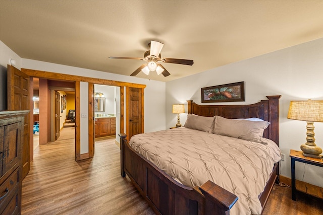 bedroom featuring wood-type flooring, ensuite bathroom, and ceiling fan