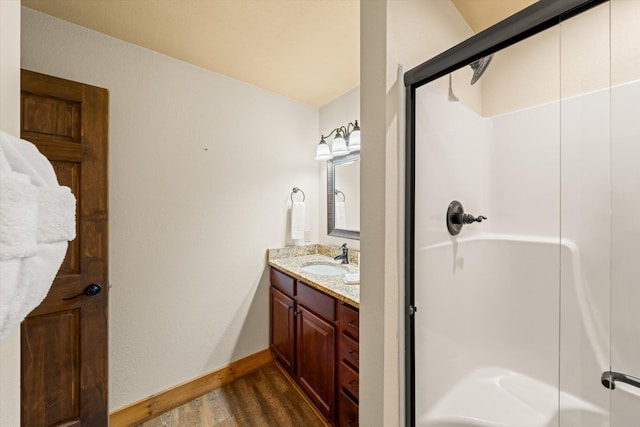 bathroom featuring a shower with door, vanity, and hardwood / wood-style flooring