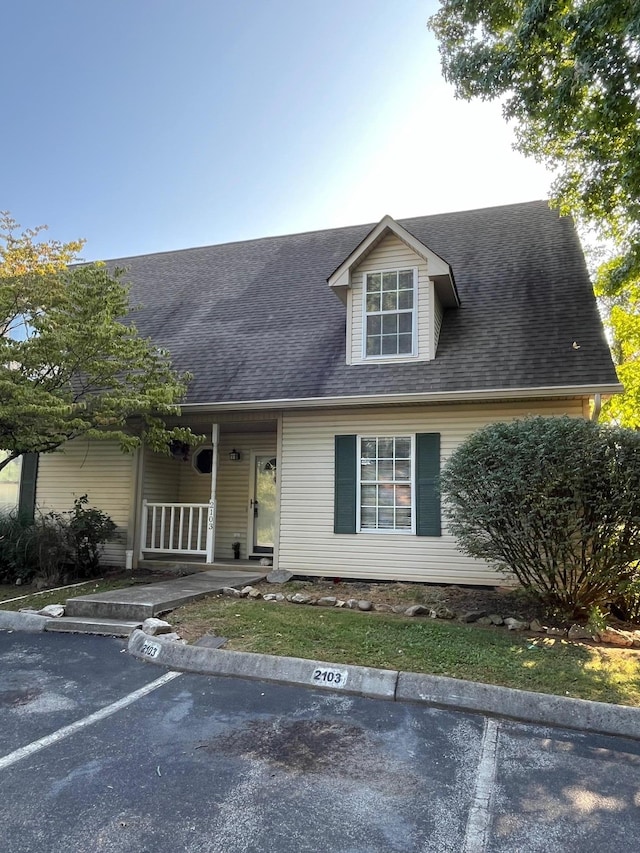 cape cod house featuring covered porch