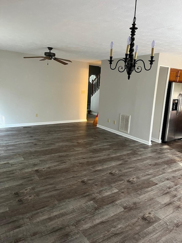 interior space with ceiling fan with notable chandelier, dark wood-type flooring, and a textured ceiling