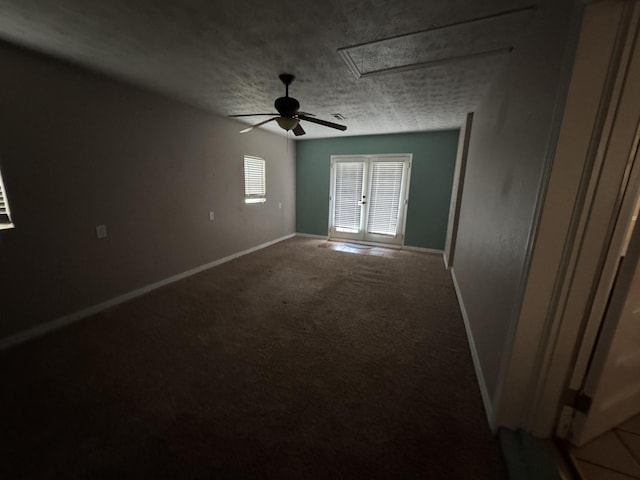 spare room with baseboards, a textured ceiling, carpet, and ceiling fan