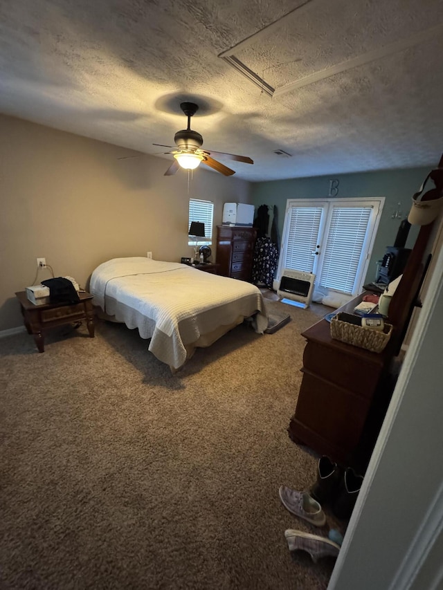bedroom featuring carpet floors, a textured ceiling, ceiling fan, and attic access