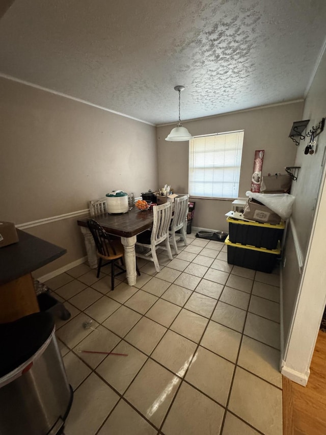 dining room with crown molding, baseboards, a textured ceiling, and light tile patterned floors