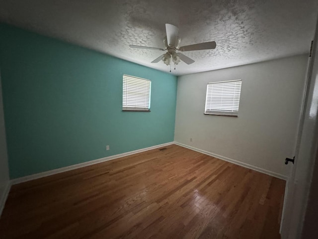 spare room with a healthy amount of sunlight, ceiling fan, and a textured ceiling