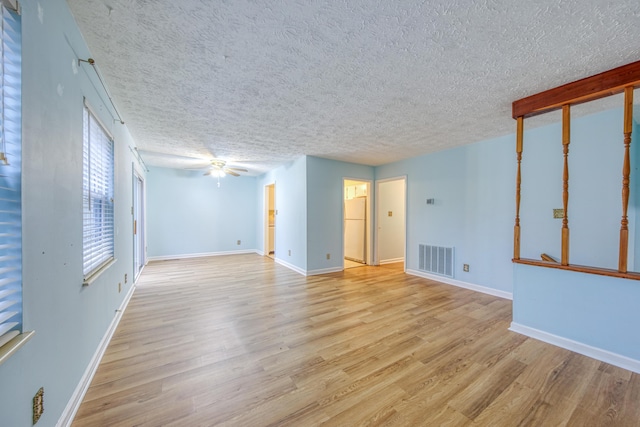 spare room featuring ceiling fan, a textured ceiling, and light hardwood / wood-style flooring