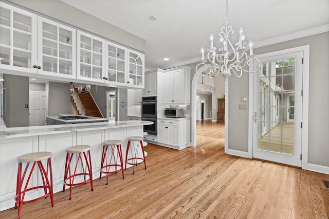 1647 Talon Ct, Talbott, TN 37877 - kitchen featuring a chandelier, appliances with stainless steel finishes, ornamental molding, light wood finished floors, and a kitchen breakfast bar