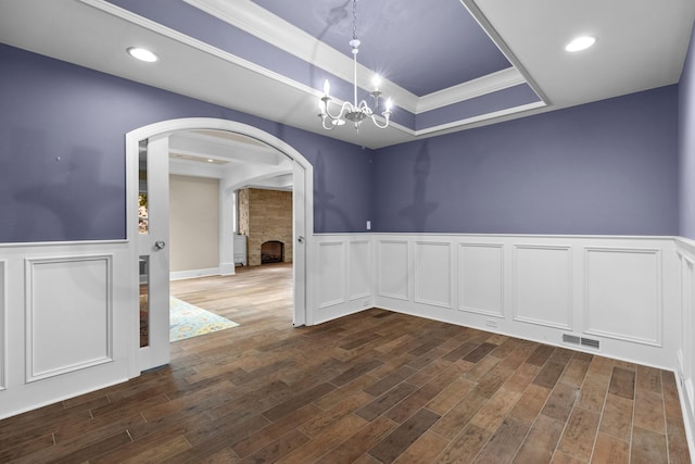 1647 Talon Ct, Talbott, TN 37877 - spare room with arched walkways, a tray ceiling, a chandelier, wainscoting, and dark wood finished floors