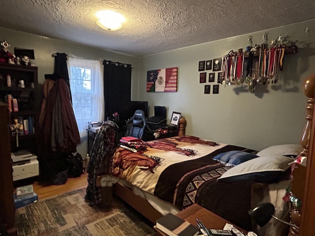 bedroom with hardwood / wood-style flooring and a textured ceiling