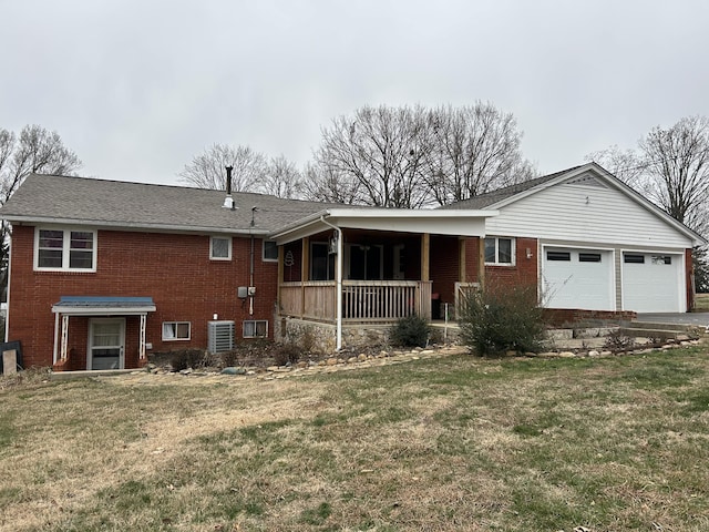 rear view of house featuring a porch, a yard, and a garage