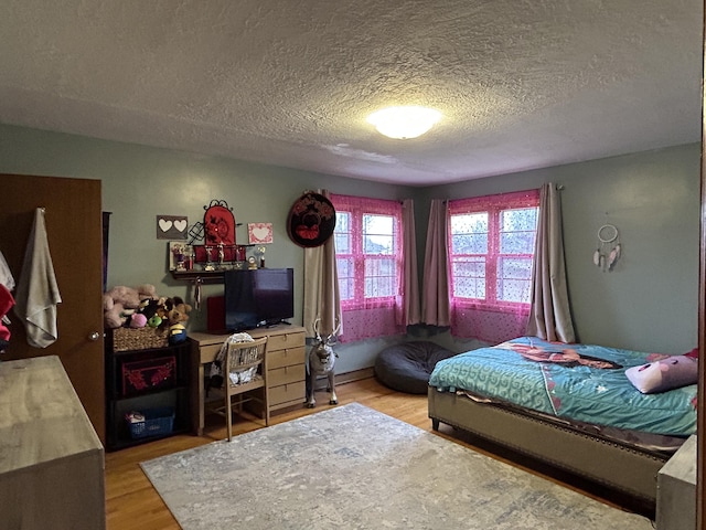 bedroom with wood-type flooring and a textured ceiling