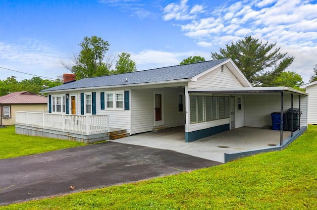 back of house featuring a yard, driveway, and a carport