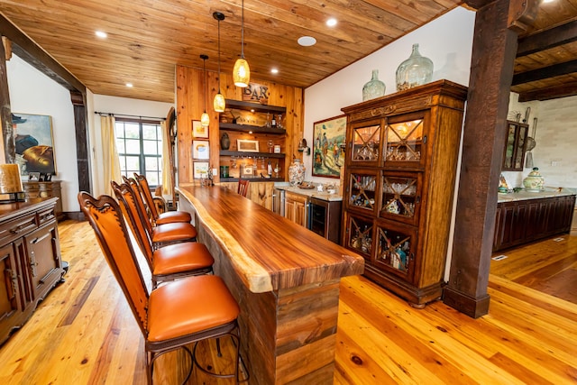 bar with pendant lighting, light wood-type flooring, and wooden ceiling