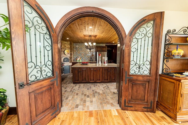 foyer entrance with wood ceiling and an inviting chandelier