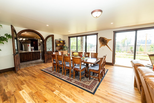 dining room with light hardwood / wood-style flooring and an inviting chandelier