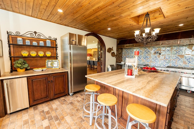 kitchen with decorative backsplash, a kitchen island, wooden ceiling, and fridge