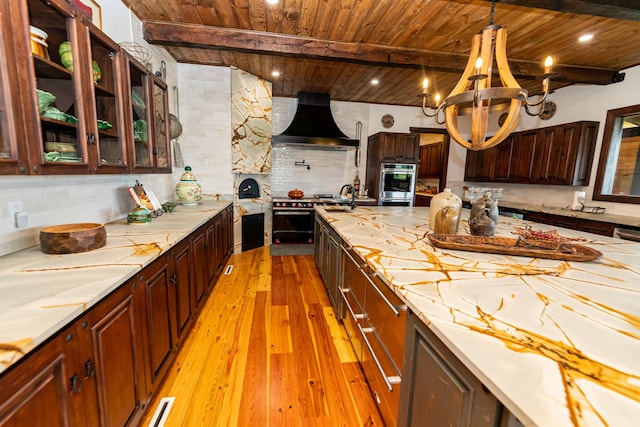 kitchen featuring beam ceiling, decorative backsplash, wooden ceiling, and wall chimney range hood