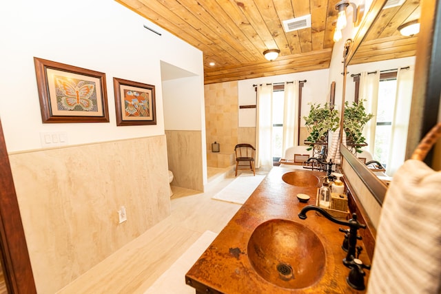 bathroom featuring a wealth of natural light, vanity, wooden ceiling, and toilet