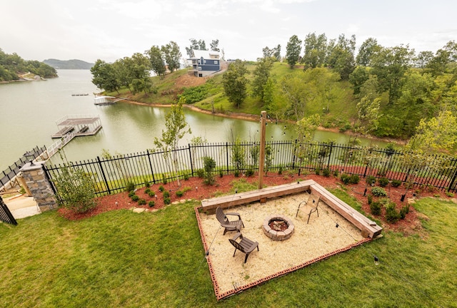 view of yard with a water view, an outdoor fire pit, and a dock