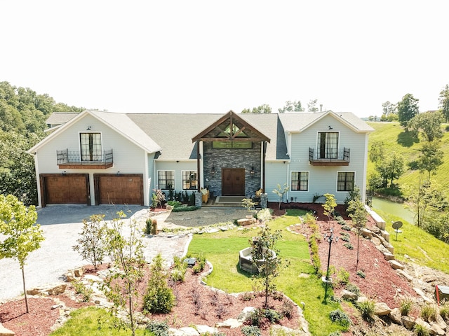 view of front of home with a balcony, a front lawn, and a garage