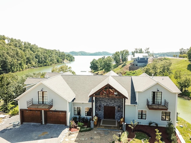 view of front of property with a water view, a garage, and a balcony