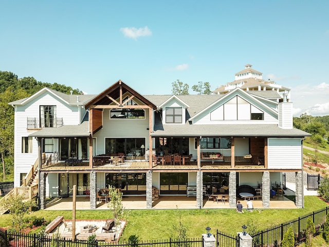 back of property with a fireplace and a patio