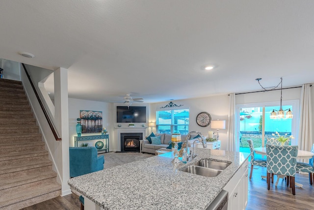 825 Greene Meadow Dr, Talbott, TN 37877 - kitchen with a sink, a ceiling fan, a fireplace with flush hearth, a kitchen island with sink, and light stone counters