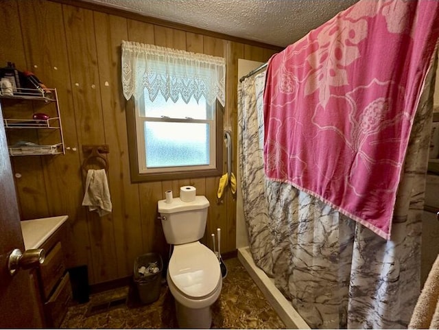 bathroom featuring a shower with shower curtain, a textured ceiling, toilet, and wood walls