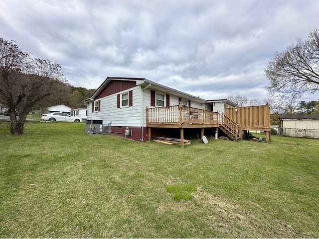 back of property featuring central air condition unit, a wooden deck, and a yard