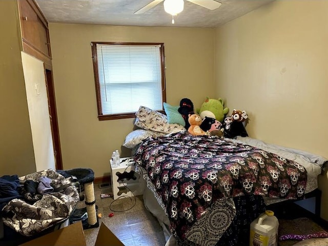 bedroom with ceiling fan and a textured ceiling