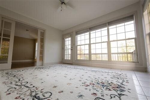 tiled spare room with ceiling fan