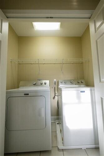 laundry area featuring light tile patterned floors and washing machine and dryer