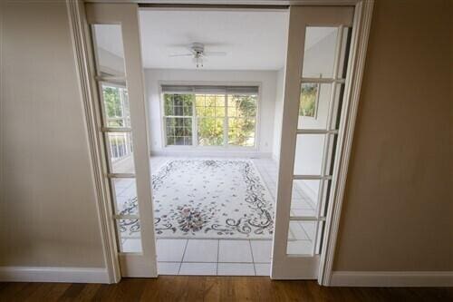 entryway with ceiling fan, french doors, and dark wood-type flooring