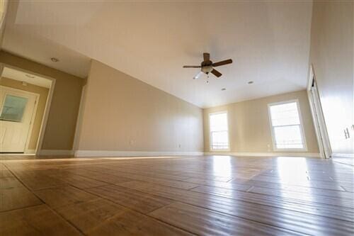 unfurnished room with ceiling fan, vaulted ceiling, and hardwood / wood-style flooring