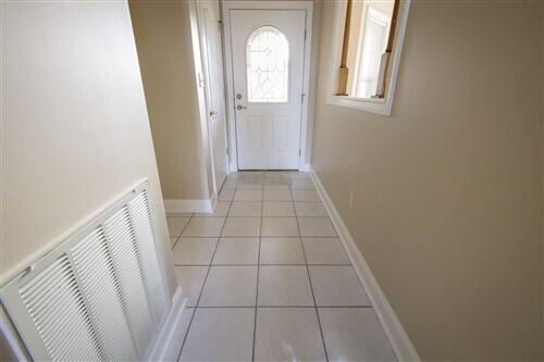 doorway with light tile patterned flooring